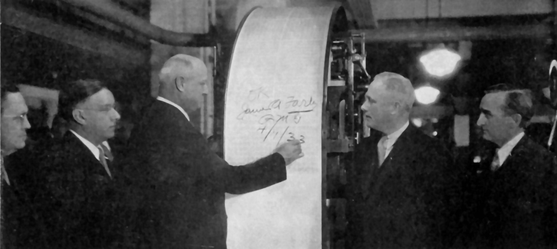 Farley signing a sheet as it comes off the press